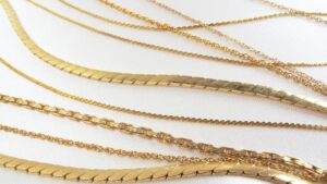an image of various yellow gold chains laying on a table to show comparison of each other