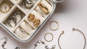 an overhead image looking down at a jewelry box with various jewelry pieces in yellow and white gold that are timeless pieces