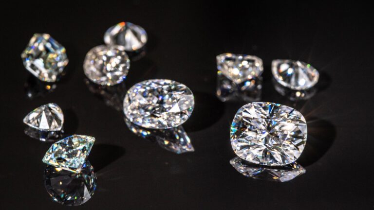 a black background with numerous natural and lab grown diamonds of various sizes resting